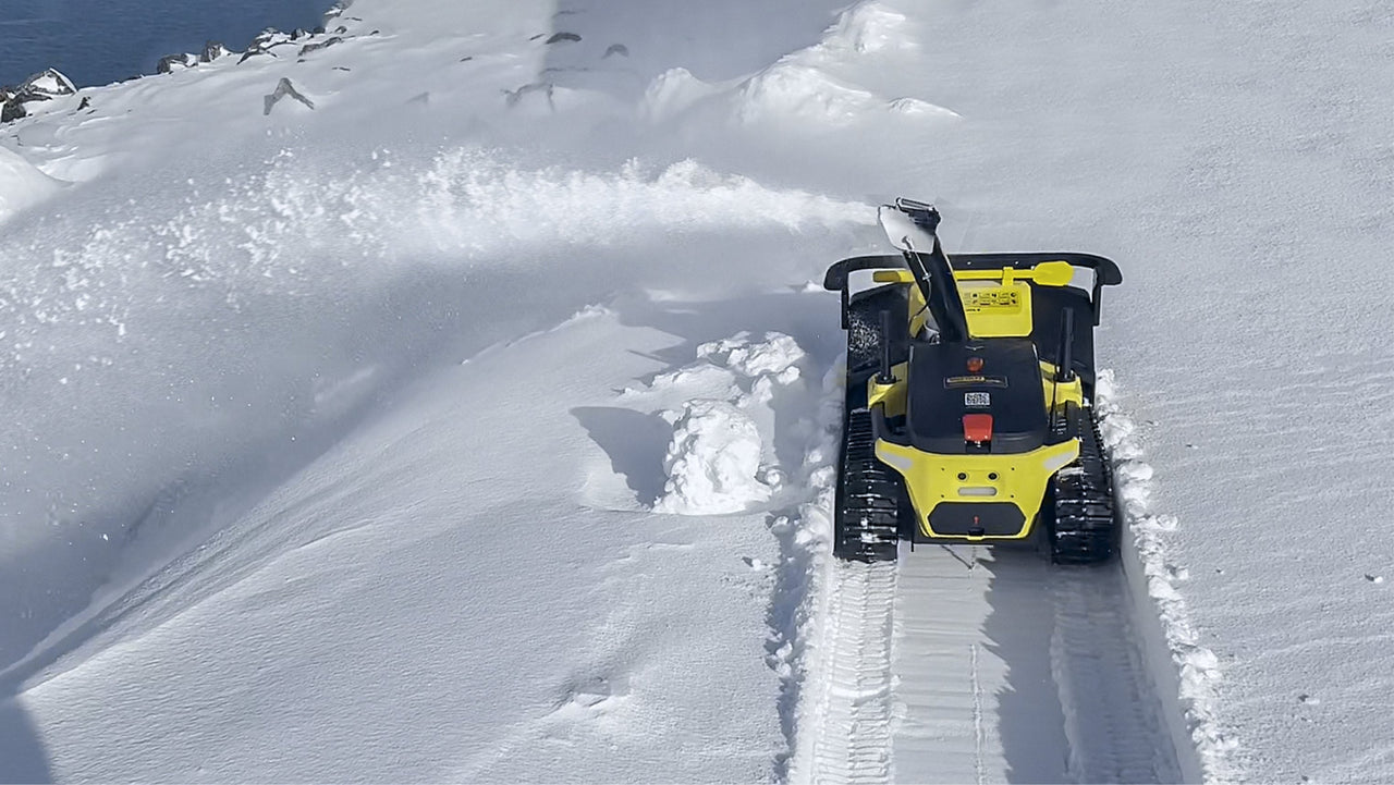 Yellow snow-clearing robot efficiently plows deep snow, creating a clean path with minimal effort.