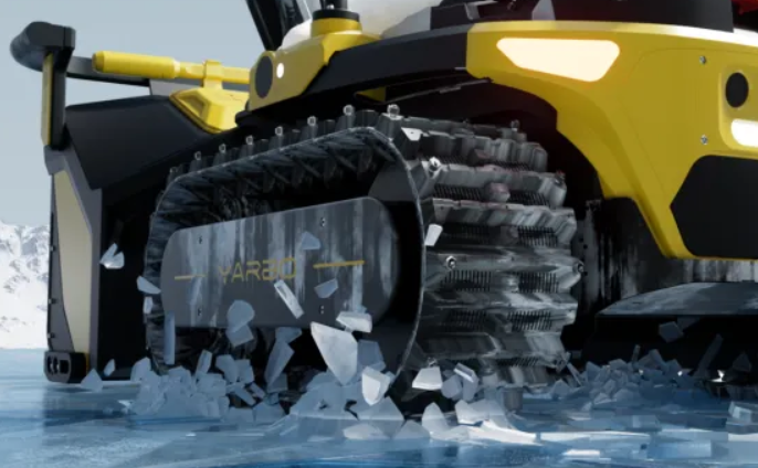 Yellow Yarbo snow blower with rugged tracks crushing ice on a steep, snowy driveway, showcasing power and traction.