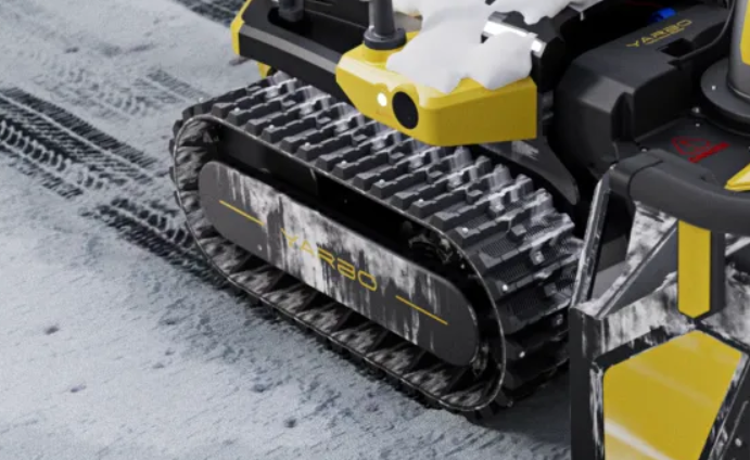 Yellow and black Yarbo snow-clearing robot on snowy ground, tracks cutting through fresh snow, ready for winter storm prep.