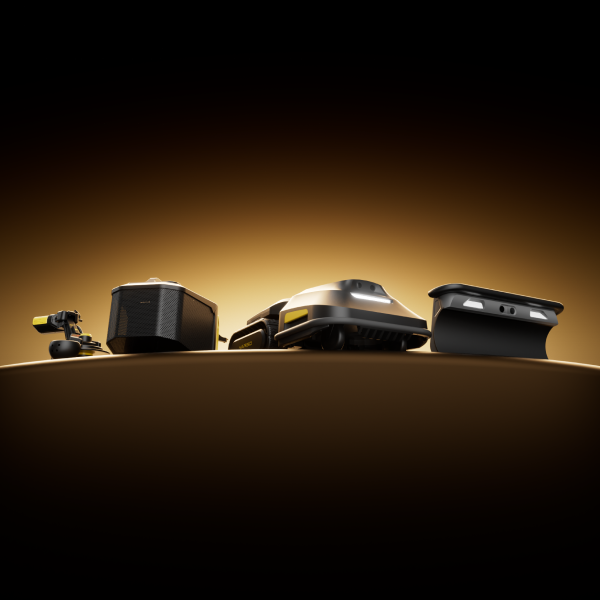 Four sleek black and yellow robotic devices arranged in a row on a curved surface, illuminated by warm golden light against a dark background.