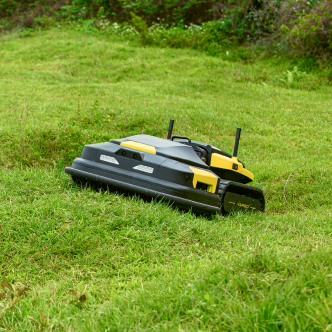 Black and yellow robotic lawn mower on green grass, outdoor garden setting, no visible text.