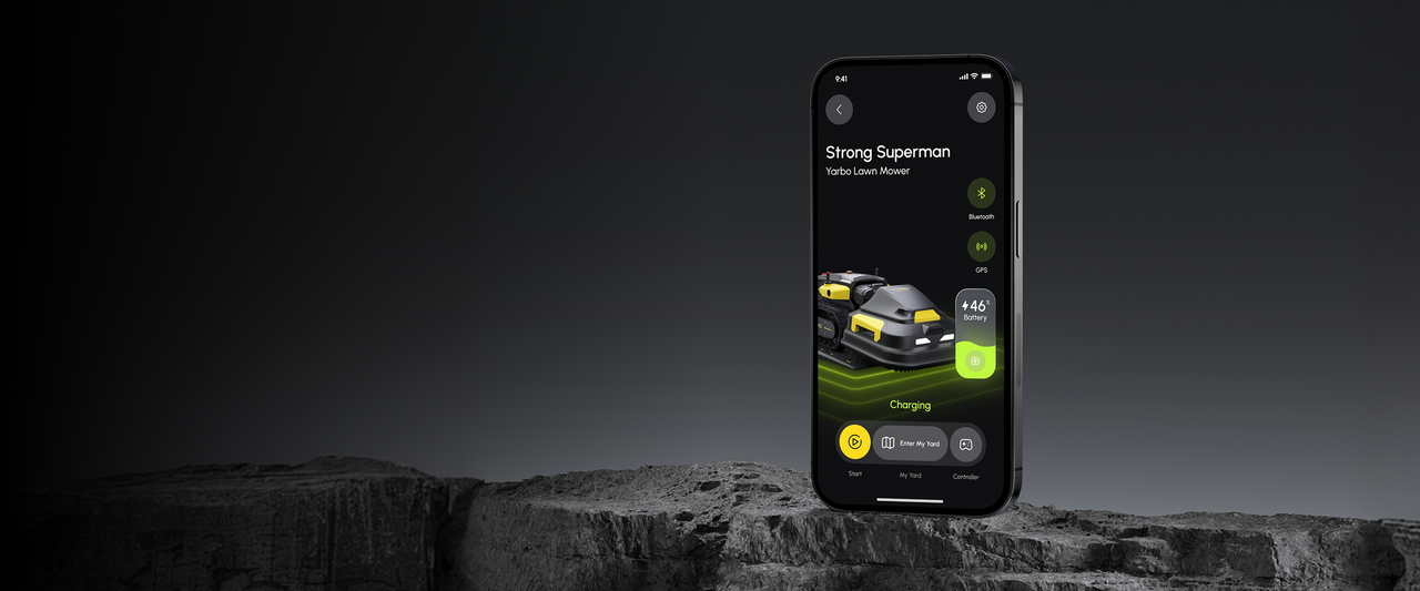 Smartphone displaying Yarbo lawn mower app interface with charging status, 46% battery, and controls on dark rocky surface.