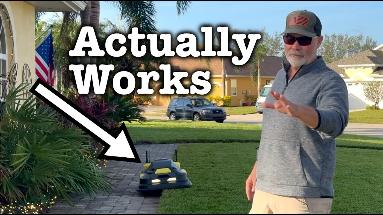 Man in gray hoodie and cap gestures toward robotic lawn mower on grass, with "Actually Works" text and arrow pointing to device.
