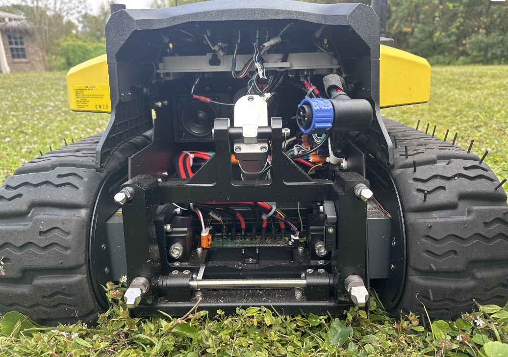 Exposed internals of Yarbo lawn robot with wires, sensors, and circuitry, showcasing DIY tech modifications on grass.