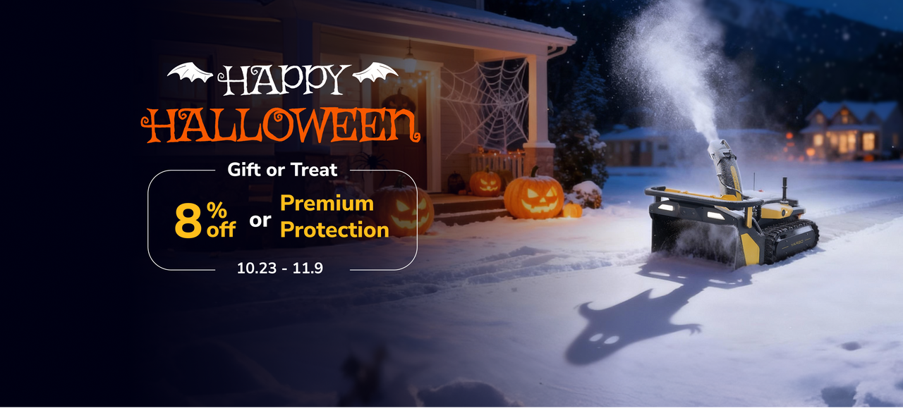 Robotic snow blower clears snowy yard at night near Halloween-decorated house with pumpkins and spiderwebs.