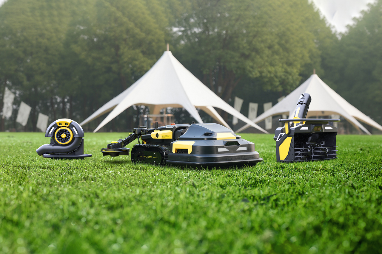 Four Yarbo robotic yard machines on lush green grass, showcasing automated lawn care with modern, sleek black and yellow designs.
