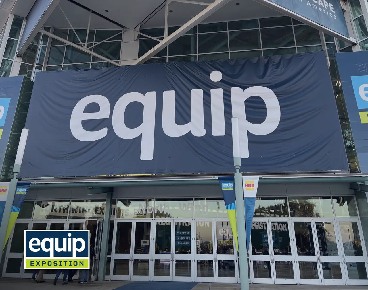 Large blue banner with white "equip" text above glass doors of exhibition center, with "equip EXPOSITION" logo in corner.