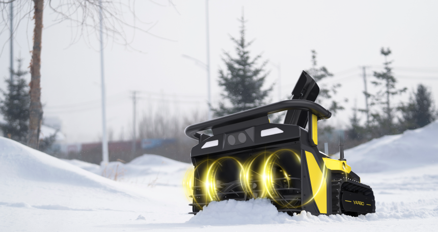 Yellow and black snow-clearing robot with glowing lights plows snow in a winter landscape with trees and overcast sky.