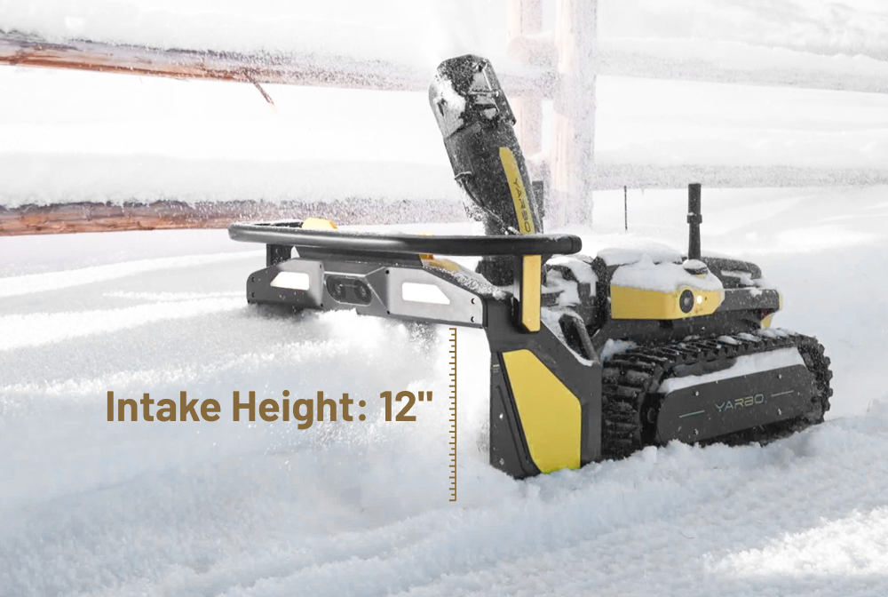 Yellow and black YARBO snow blower clearing snow, intake height 12 inches, snow-covered ground and fence in background.