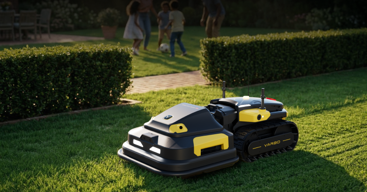 Two black and yellow robotic lawn mowers on green grass, with family playing soccer in background.