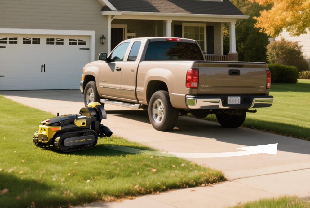 Yellow and black VARBO robotic lawn mower on green grass beside beige pickup truck in driveway.