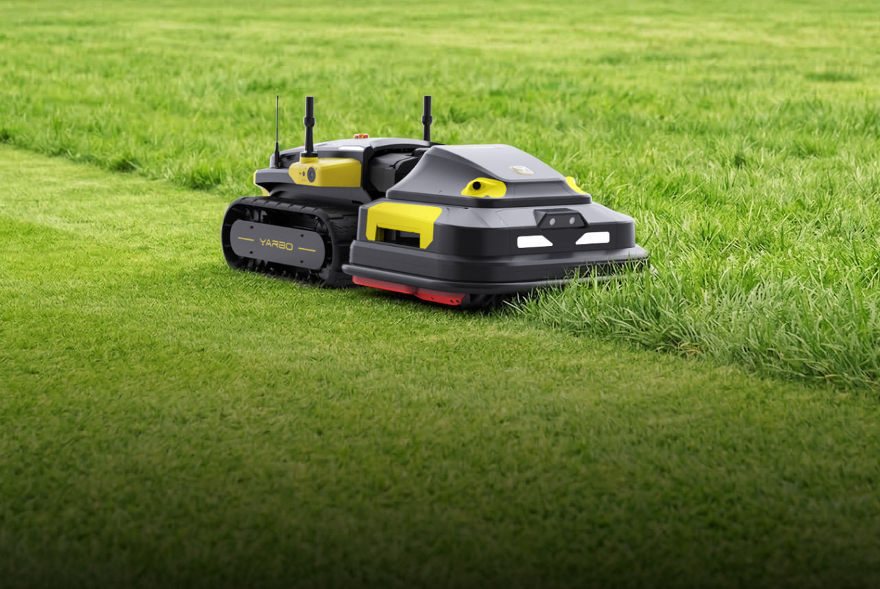 Black and yellow YARBO robotic lawn mower on vibrant green grass, cutting a neat path.