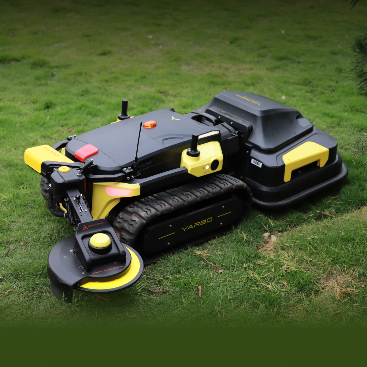 Black and yellow robotic lawn mower with tracked base and attachments by Yarbo, shown on grass in outdoor setting