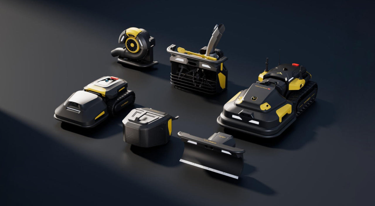 Six black and yellow robotic lawn and garden tools arranged on a dark surface, including mowers, a blower, and attachments.