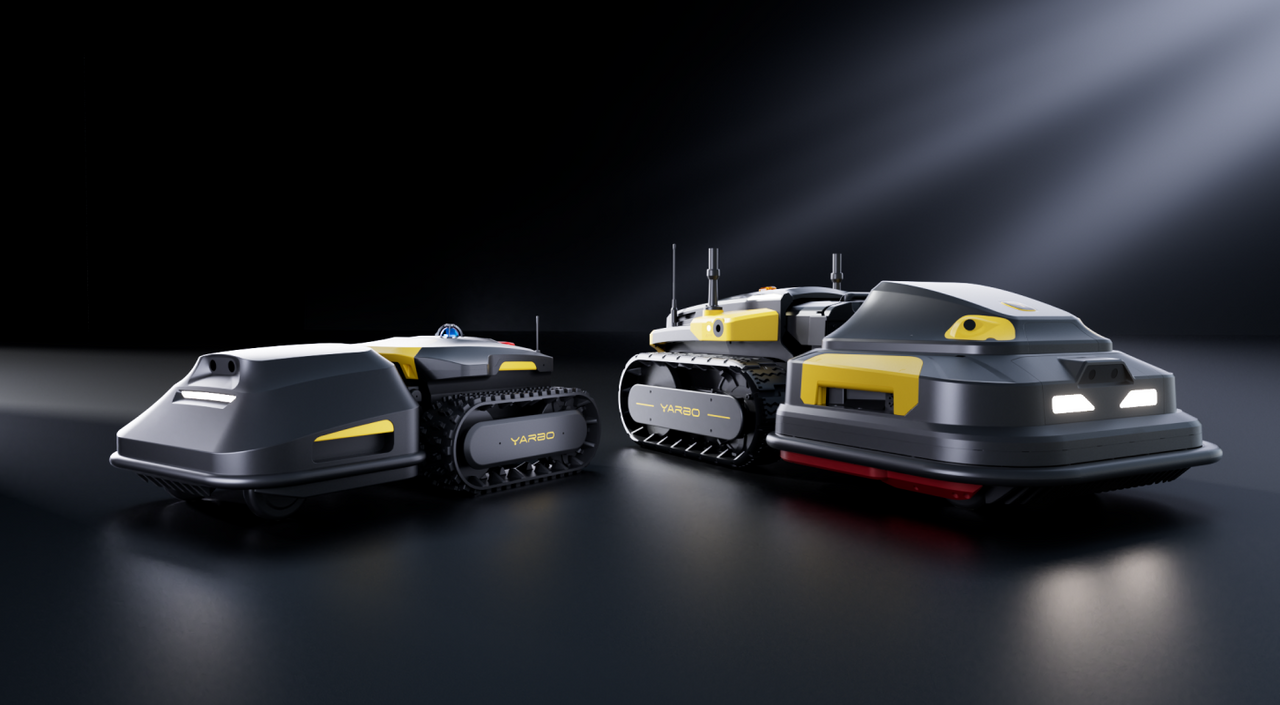 Two gray and yellow YARBO tracked robots on dark surface, illuminated by spotlight, showcasing sleek futuristic design.