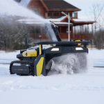 Black and yellow robotic snow blower by Yarbo clearing snow in winter yard, side view with tracks and illuminated panel