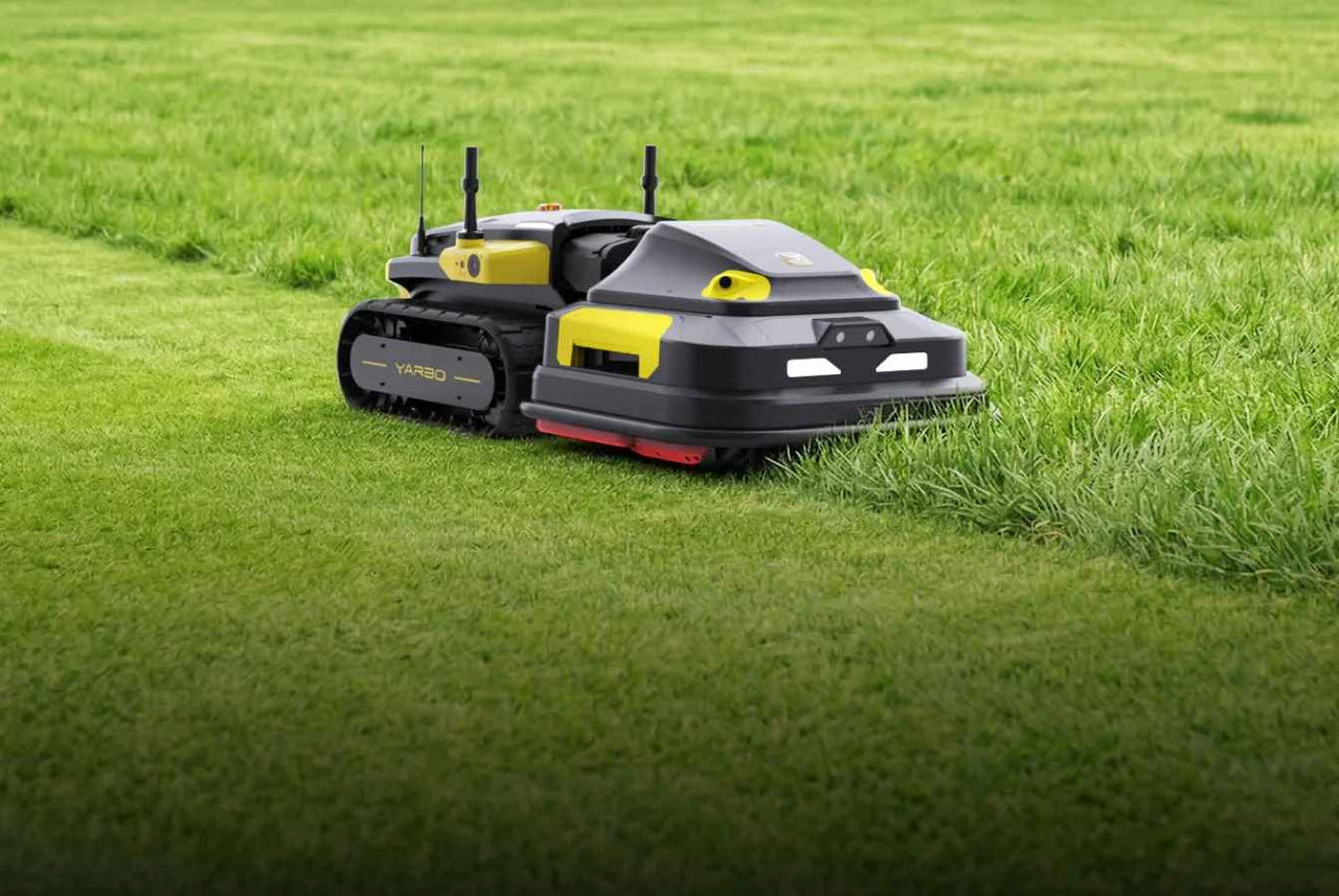 Black and yellow YARBO robotic lawn mower on vibrant green grass, cutting path, bright daylight.